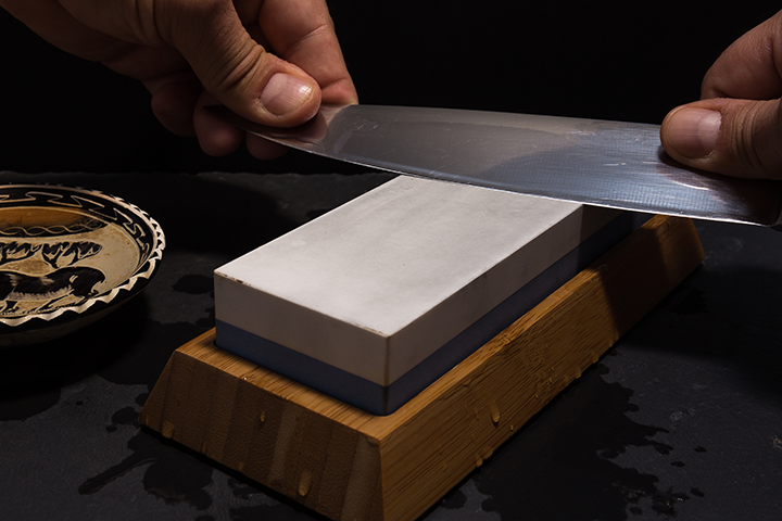 https://www.knifesupplies.com.au/assets/images/knife-sharpening-on-white-whetstone-with-wooden-base.png